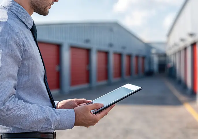 Manager using digital tablet monitoring self storage units central il
